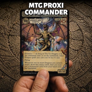 Puede incluir: Una carta coleccionable rectangular con una ilustración central de un gran dragón con las alas extendidas sobre un fondo cósmico. La carta incluye el texto MTG PROXI COMMANDER, The Ur-Dragon, Eminence, Flying y una calificación de 10/10.