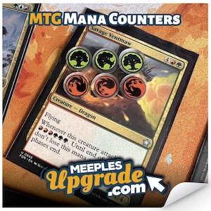 May include: Image of MTG Mana Counters. The image shows a Magic: The Gathering card with six clear acrylic counters. Three counters have a black tree design with a green outline, and three have a black and orange design. The text "MTG Mana Counters" and "MEEPLES Upgrade.com" are visible.