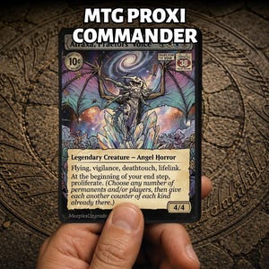 以下が含まれることがあります： MTG PROXI COMMANDERと題された長方形のトレーディングカード。キャラクター「Atraxa, Praetors' Voice」が描かれています。アートワークには、宇宙を背景にクリスタルの上に立つ翼のあるクリーチャーが表現されています。テキストには、Legendary Creature - Angel Horror、flying、vigilance、deathtouch、lifelink、および増殖ルールが含まれています。