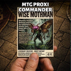 以下が含まれることがあります： MTG PROXI COMMANDER WISE MOTHMANおよびAUG 1974のテキストが記載された長方形のトレーディングカード。カードには、沼地の森の中にいる、光る紫色の目をした茶色の蛾のような生き物が描かれており、ゲームのルールテキストと4/4のパワー評価が含まれています。