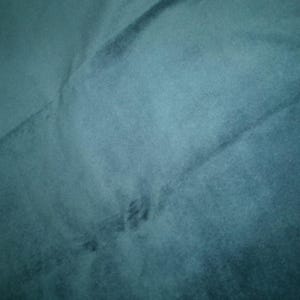 Może przedstawiać: Zbliżenie miękkiej, turkusowej tkaniny o subtelnej fakturze. Tkanina ma gładką, r&oacute;wnomierną powierzchnię z lekkim połyskiem.