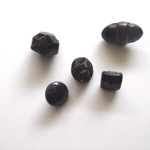 May include: Assortment of six black glass buttons in various shapes and sizes.