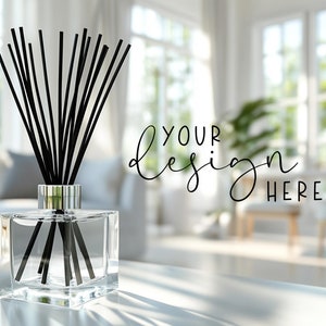 May include: A white ceramic mug with a black handle and the text "But First, Coffee" in a bold, black font. The mug is set against a blurred background, suggesting a cozy setting.