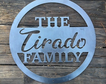 May include: A circular metal sign with the words "The Tirado Family" cut out in a decorative font.