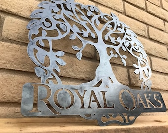 Könnte beinhalten: Eine Wanddekoration aus Metall in Form eines Lebensbaums mit einem dekorativen Design und den Worten "ROYAL OAKS" am unteren Rand.