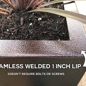 May include: A close-up of a brown metal planter with a 1-inch lip. The lip is seamless and welded, so it doesn't require bolts or screws. The planter is filled with soil and a plant.