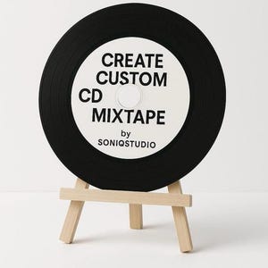 May include: A black CD with a white label that reads "CREATE CUSTOM CD MIXTAPE" by SONIQSTUDIO. The CD is displayed on a small wooden easel, set against a plain white background. The CD resembles a vinyl record.