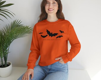 Könnte beinhalten: Orangefarbener Pullover mit einem schwarzen Aufdruck von Fledermäusen und dem Text "It's Frickin Bats".