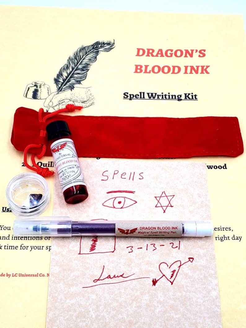 May include: Dragon's Blood Ink Spell Writing Kit with a red velvet pouch, a small bottle of ink, a quill pen, and a piece of obsidian. The kit also includes a sheet of paper with various symbols and the text "Spells" written on it. The pen is labeled "Dragon Blood Ink Magical Spell Writing Pen" and the date "3-13-21" is written on the paper.
