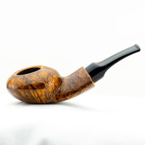 Puede incluir: Una pipa de madera marrón con una boquilla negra. La pipa tiene una cazoleta redonda y una boquilla curva.