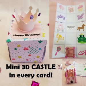 May include: A pink and white 3D pop-up card with a castle design. The card has a pink crown on top and the words "Happy Birthday!" on the front. The card is decorated with stars and stripes. The text "Mini 3D CASTLE in every card!" is written below the card.