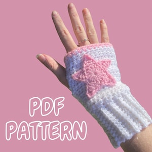 May include: White and pink crochet fingerless gloves with a star design. The gloves have a ribbed cuff and a pink star in the center. The text "PDF PATTERN" is displayed in white letters.