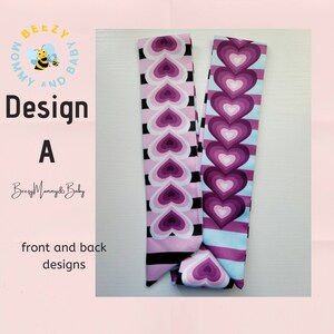 May include: A pink and purple fabric headband with a repeating pattern of hearts. The headband has a black and white striped pattern on one side and a light blue and white striped pattern on the other side. The text "Design A" is visible in the image.