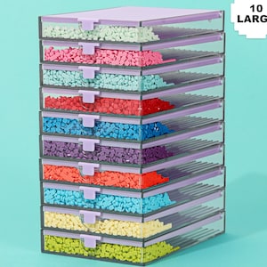 May include: A stack of ten clear plastic storage containers with lavender lids and clasps. Each container is filled with small, colorful, square-shaped objects. The containers are arranged in a neat, organized manner, with the text "10 LARGE" in the upper right corner.