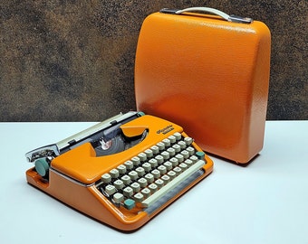 retro writing with the Olympia Splendid 33/66 typewriter orange - a fully refurbished vintage writing machine with a matching carrying case.