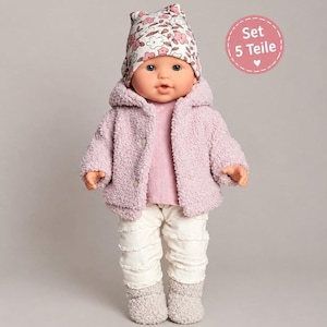 May include: A doll wearing a floral print beanie, a light purple textured fleece jacket, a light purple long-sleeve shirt, and white ruffled trousers. A circular pink badge in the upper right corner displays the text Set 5 Teile.