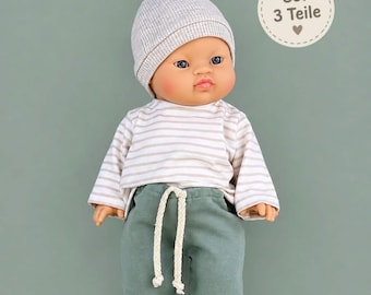May include: A doll wearing a light gray ribbed beanie with a top knot, a long-sleeved shirt with horizontal beige and white stripes, and solid sage green pants featuring a white drawstring. A circular label reads Set 3 Teile.