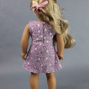 This 18 inch doll Shirred Front Dress PDF Sewing pattern is styled from the 1970s. This dress has a center front panel with shirring in the bodice extends to the skirt. There are two options for shirring in the center front panel. You may sew gathers and then apply a ⅛ to ¼ inch ribbon or gather the front section with elastic for a smocked effect. There are two sleeve options for the dress: a puff sleeve option or sleeveless. The neckline on dress is square and the skirt is semi-full.