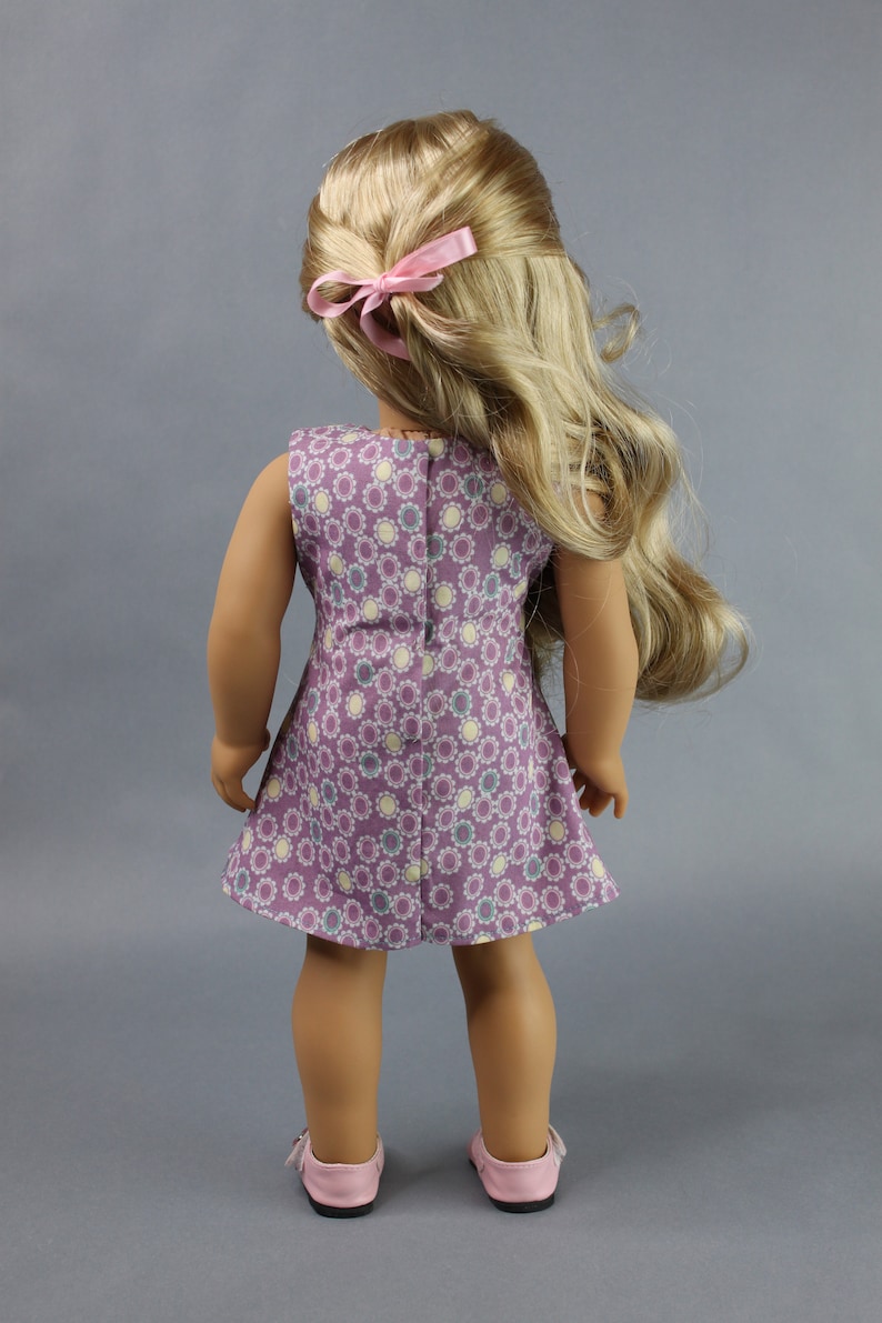 This 18 inch doll Shirred Front Dress PDF Sewing pattern is styled from the 1970s. This dress has a center front panel with shirring in the bodice extends to the skirt. There are two options for shirring in the center front panel. You may sew gathers and then apply a ⅛ to ¼ inch ribbon or gather the front section with elastic for a smocked effect. There are two sleeve options for the dress: a puff sleeve option or sleeveless. The neckline on dress is square and the skirt is semi-full.