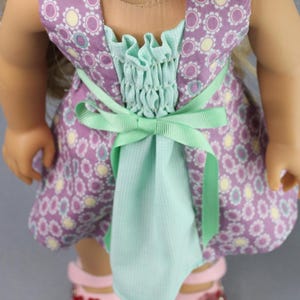 This 18 inch doll Shirred Front Dress PDF Sewing pattern is styled from the 1970s. This dress has a center front panel with shirring in the bodice extends to the skirt. There are two options for shirring in the center front panel. You may sew gathers and then apply a ⅛ to ¼ inch ribbon or gather the front section with elastic for a smocked effect. There are two sleeve options for the dress: a puff sleeve option or sleeveless. The neckline on dress is square and the skirt is semi-full.