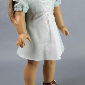 This 18 inch doll Shirred Front Dress PDF Sewing pattern is styled from the 1970s. This dress has a center front panel with shirring in the bodice extends to the skirt. There are two options for shirring in the center front panel. You may sew gathers and then apply a ⅛ to ¼ inch ribbon or gather the front section with elastic for a smocked effect. There are two sleeve options for the dress: a puff sleeve option or sleeveless. The neckline on dress is square and the skirt is semi-full.