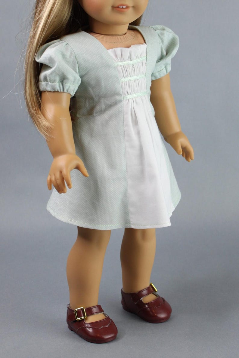 This 18 inch doll Shirred Front Dress PDF Sewing pattern is styled from the 1970s. This dress has a center front panel with shirring in the bodice extends to the skirt. There are two options for shirring in the center front panel. You may sew gathers and then apply a ⅛ to ¼ inch ribbon or gather the front section with elastic for a smocked effect. There are two sleeve options for the dress: a puff sleeve option or sleeveless. The neckline on dress is square and the skirt is semi-full.