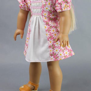 This 18 inch doll Shirred Front Dress PDF Sewing pattern is styled from the 1970s. This dress has a center front panel with shirring in the bodice extends to the skirt. There are two options for shirring in the center front panel. You may sew gathers and then apply a ⅛ to ¼ inch ribbon or gather the front section with elastic for a smocked effect. There are two sleeve options for the dress: a puff sleeve option or sleeveless. The neckline on dress is square and the skirt is semi-full.