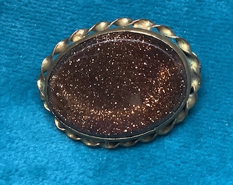 Broche antiguo de piedra dorada