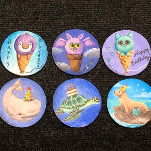 May include: Six round, colorful, painted paper circles with different animals wearing party hats and holding ice cream cones. The text "Happy Birthday" is written on one of the circles.