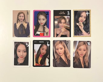 May include: Eight photo cards featuring a K-pop group. The cards are arranged in two rows of four. Each card features a different member of the group. The cards are all white with black borders. The cards are numbered 1 through 8.