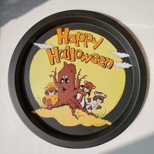 Peut inclure: Plateau de service rond noir pour Halloween avec un centre jaune représentant un arbre de dessin animé et trois ours costumés. Les mots "Happy Halloween" sont écrits en orange. Une décoration festive.