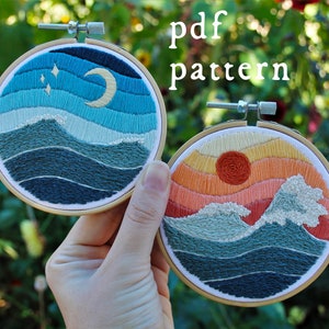 Peut inclure: Deux broderies en cercle sur le thème de la nature. Le cercle de gauche représente un ciel nocturne bleu et blanc avec une lune croissante et des étoiles au-dessus d'un océan bleu et vert. Le cercle de droite représente un coucher de soleil avec un soleil rouge et un ciel orange et jaune au-dessus d'un océan bleu et vert.