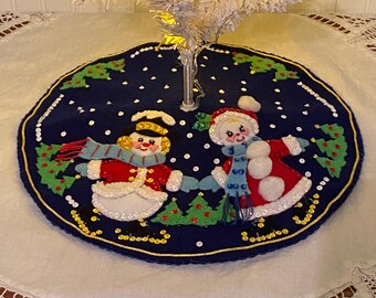 Finished with a backing 14 inch VTG felt  tree skirt entitled “Skating Couple “
