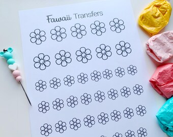 Op de afbeelding: Een vel wit papier met de tekst "Kawaii Transfers" bovenaan. Het papier is gevuld met een raster van zwarte en witte bloem contouren.