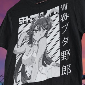 Könnte beinhalten: Schwarzes T-Shirt mit einem weißen Grafikdruck eines Anime-Charakters mit langen schwarzen Haaren und einem weißen Outfit. Der Text "SAKURA" und japanische Schriftzeichen sind auf dem Shirt gedruckt.