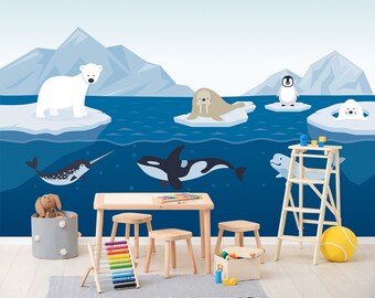 May include: A blue and white illustrated wall mural depicting arctic animals, including a polar bear, walrus, penguin, narwhal, orca, and beluga whale. The mural is displayed in a room with a wooden table, chairs, and a ladder.