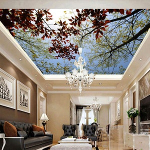 Könnte beinhalten: Ein Wohnzimmer mit einem Deckengemälde, das einen blauen Himmel mit Baumästen und roten Blättern darstellt. Der Raum hat ein braunes Ledersofa, einen Kronleuchter und einen Fernseher.