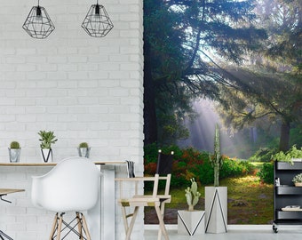 May include: A white brick wall with two black pendant lights hanging from the ceiling. The wall is next to a forest scene with sunbeams shining through the trees. There are plants and a table with chairs in the foreground.