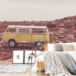 Puede incluir: Una camioneta vintage amarilla estacionada en un paisaje rocoso de color marrón rojizo. La camioneta tiene un techo blanco y molduras blancas alrededor de las ventanas. La camioneta está estacionada frente a una ladera rocosa.