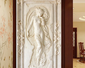 May include: A white 3D wall sculpture of a woman in a flowing robe, framed with ornate details. The sculpture is set against a white background.