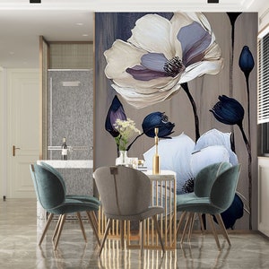 Puede incluir: Un comedor con un papel tapiz floral con grandes flores blancas y moradas con acentos azul oscuro. La habitación tiene una mesa con cuatro sillas, dos de las cuales son de color turquesa y dos de las cuales son marrones.