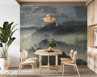 May include: A dining room with a wooden table and four chairs. The wall behind the table features a scenic wallpaper depicting a misty forest landscape.
