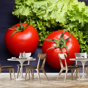 May include: Two red tomatoes and a bunch of green lettuce on a dark blue wooden surface. The tomatoes are ripe and juicy, and the lettuce is fresh and crisp.