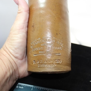 May include: A brown stoneware bottle with a label that reads "Genuine Stoneware Malt Vinegar, G. Goudie & Son, Manufacturers, Sidney, Rotherham, Trade Mark, E.A.T. Arnold's, London".