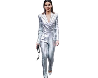May include: A silver metallic jumpsuit with a double-breasted blazer style. The jumpsuit has a fitted silhouette and a slightly flared leg.