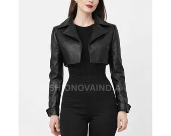 Könnte beinhalten: Schwarze, kurze Lederjacke mit Reverskragen und langen Ärmeln. Die Jacke wird über einem schwarzen Oberteil und mit einer schwarzen Hose getragen. Der Text "FASHIONOVAINDA" ist im Bild sichtbar.