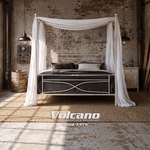 May include: A cream-colored canopy bed with white draping and a dark gray bedspread. The bed frame has a decorative design. The image includes a woven rug, a nightstand, and the text "Volcano Handmade Iron Bedrooms Since 1976."