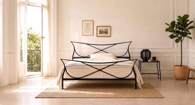 May include: A black metal bed frame with a unique, curved design. The bed is made up with a cream-colored comforter and pillows. The room has a neutral color palette, with a rug, side table, and a potted plant. The bed frame is approximately 78 inches long.