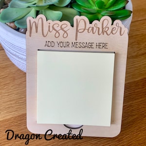 May include: A wooden note holder with the text "Miss Parker" and "Add your message here". The holder has a yellow sticky note attached to it. The text "Dragon Created" is visible at the bottom of the image.