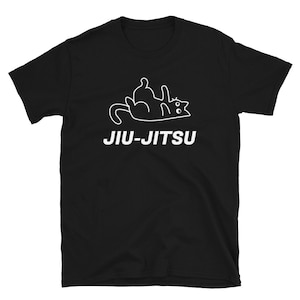 Puede incluir: Camiseta negra con un contorno blanco de un gato haciendo un movimiento de jiu-jitsu. El texto "JIU-JITSU" está impreso en blanco debajo del gato.